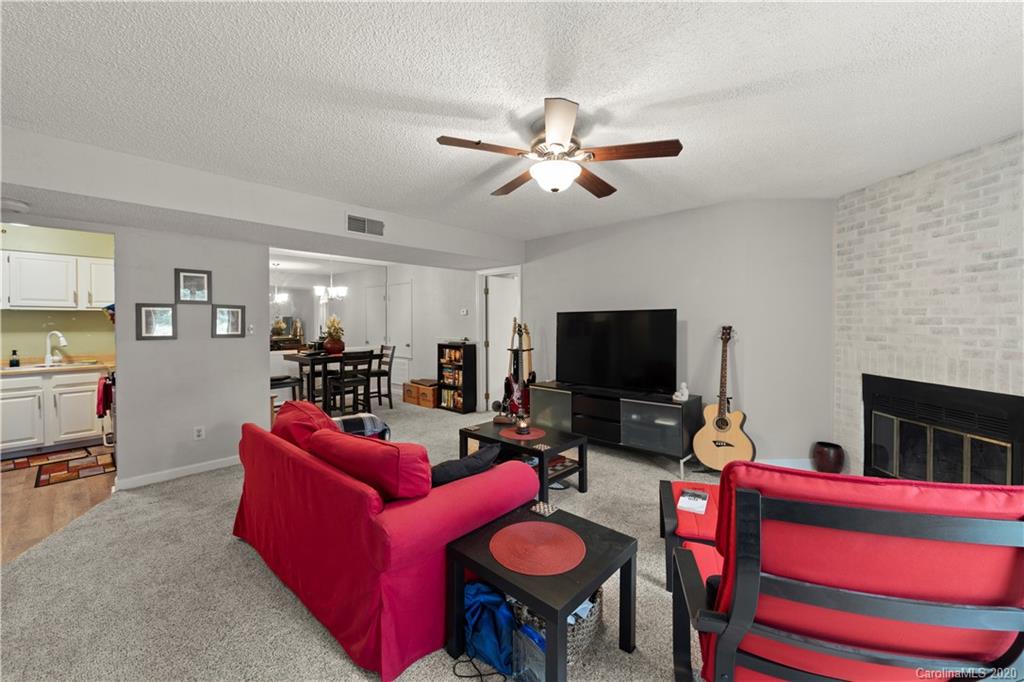 1606 Sharon Road West, Unit 33 Charlotte, NC 28210 - Photo 3 of 19 a living room with furniture a flat screen tv and kitchen view