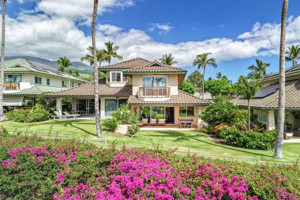 a front view of a house with a big yard and potted plants