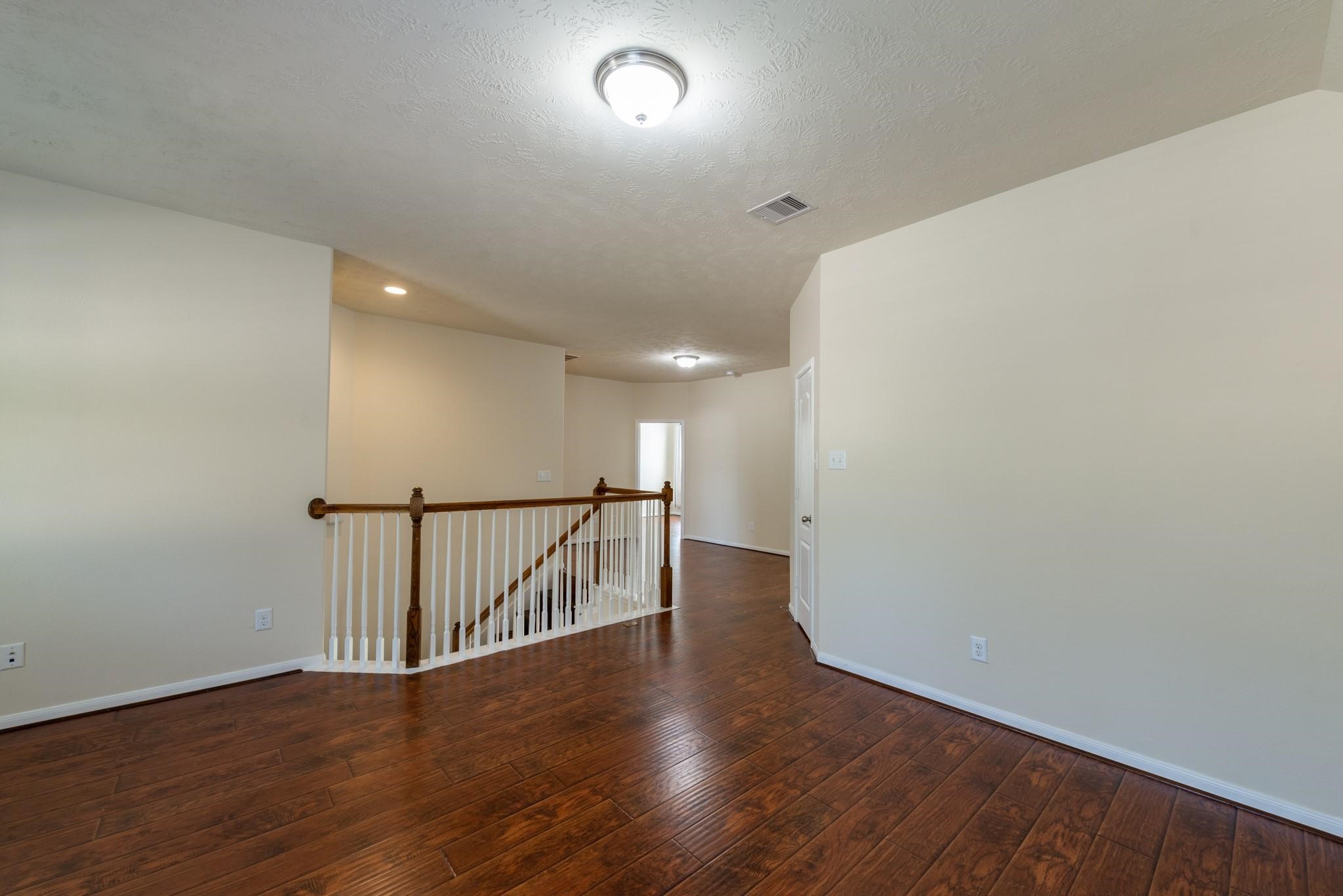 6402 Addlestone Ridge Lane Katy, TX 77494 - Photo 18 of 25 Versatile upstairs game room offers endless possibilities as a media room, playroom, home office, fitness area, or second living space. Rich wood-look flooring and the open layout create a bright, inviting area perfect for relaxing, entertaining, or family activities.