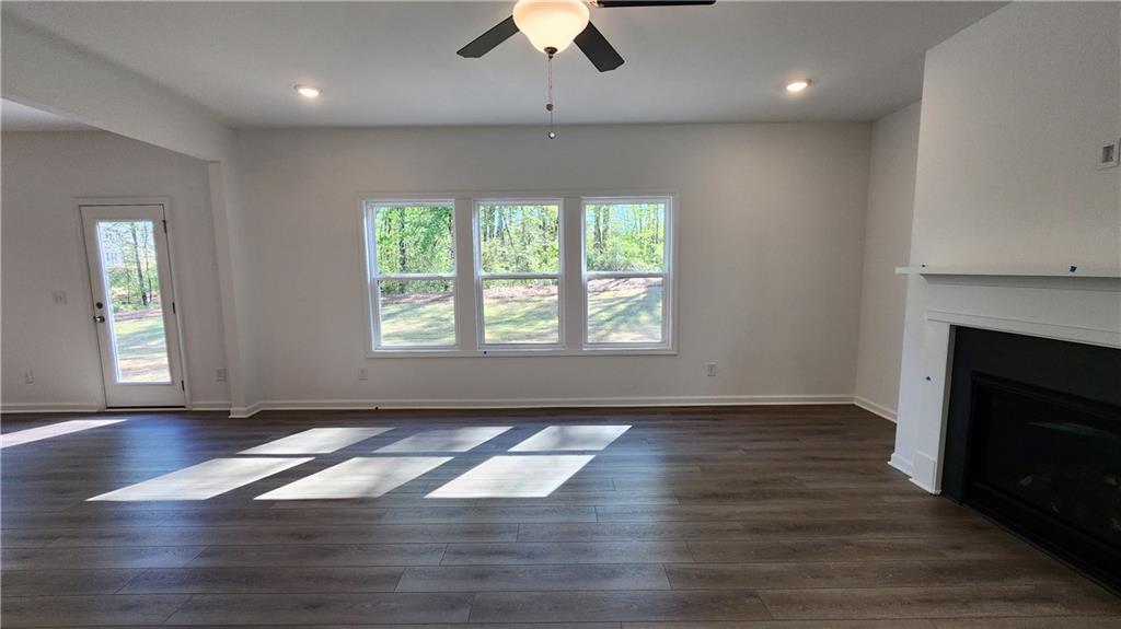 204 Silverleaf Trail Bethlehem, GA 30620 - Photo 14 of 41 an empty room with wooden floor a ceiling fan and windows