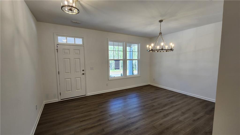 204 Silverleaf Trail Bethlehem, GA 30620 - Photo 6 of 41 an empty room with wooden floor chandelier and windows