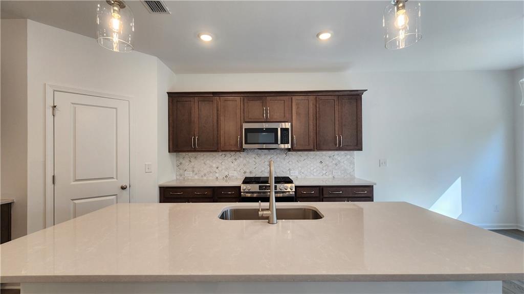 204 Silverleaf Trail Bethlehem, GA 30620 - Photo 8 of 41 a kitchen with kitchen island a sink stainless steel appliances and cabinets