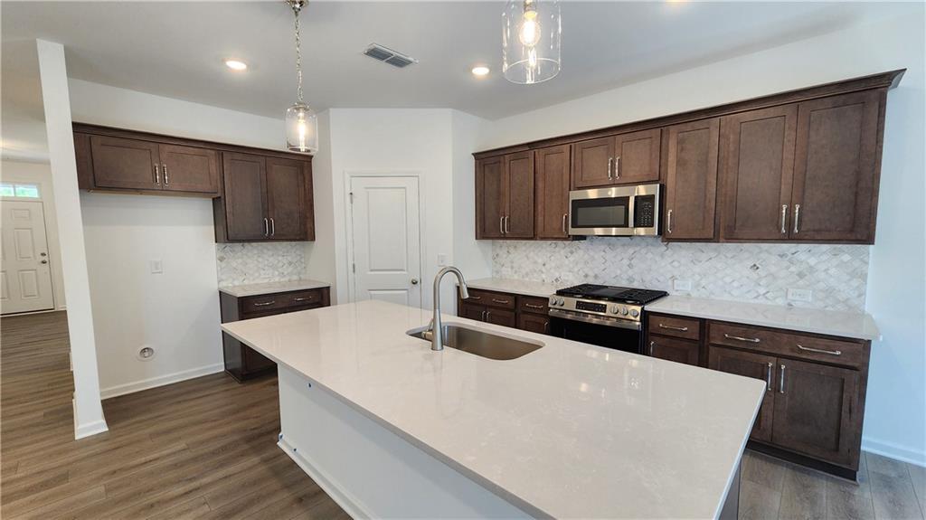 204 Silverleaf Trail Bethlehem, GA 30620 - Photo 9 of 41 a kitchen with stainless steel appliances a sink a stove top oven a counter space and cabinets