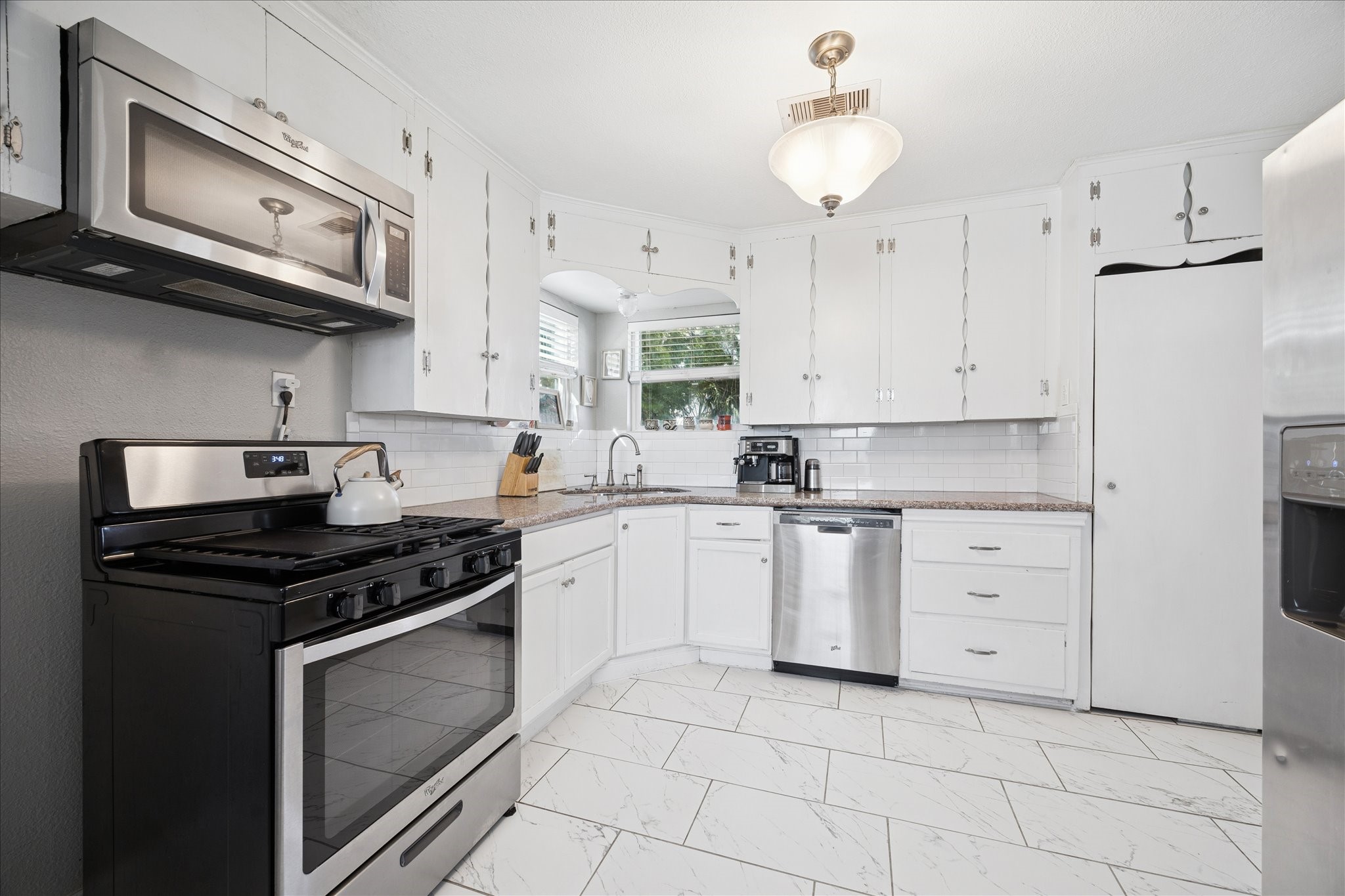 5651 Truett Street Houston, TX 77023 - Photo 9 of 19 a kitchen with cabinets stainless steel appliances and a fireplace