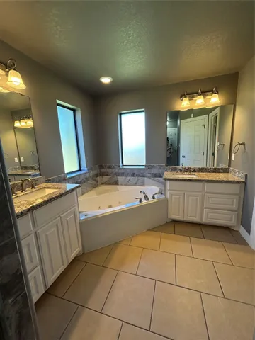 a bathroom with a sink a large mirror and a bathtub