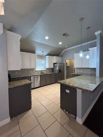 a large kitchen with granite countertop a large counter top and utility