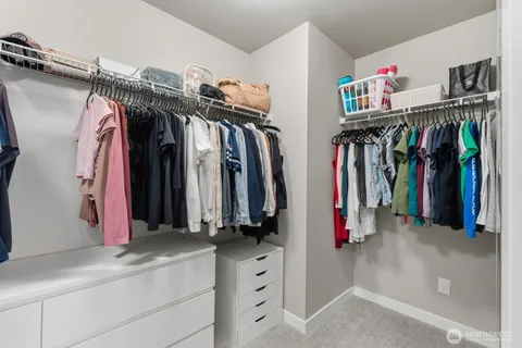 a view of walk in closet with clothes