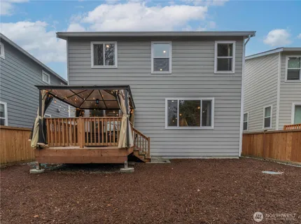 a view of a house with a yard and wooden fence