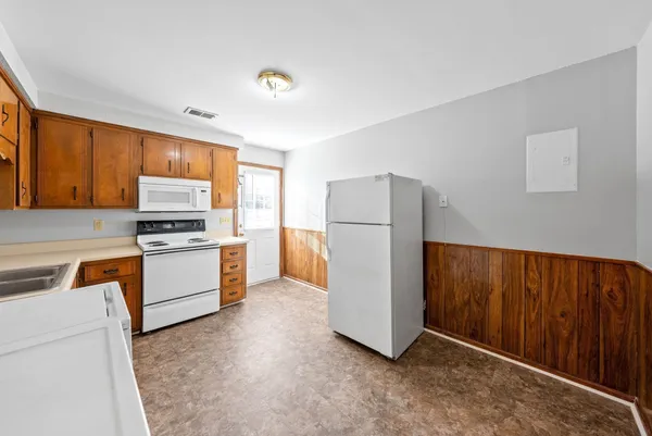 a kitchen with a refrigerator sink stove and cabinets