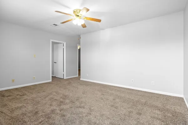 an empty room with closet and a chandelier fan