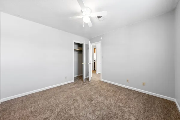 an empty room with a ceiling fan and a ceiling fan