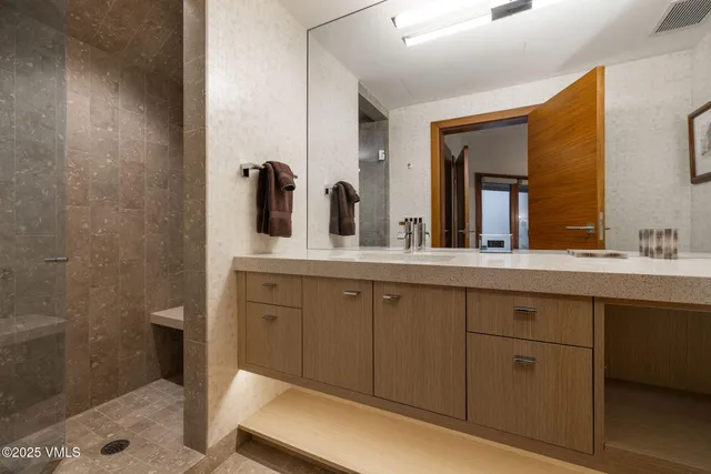 a spacious bathroom with a double vanity sink and a mirror