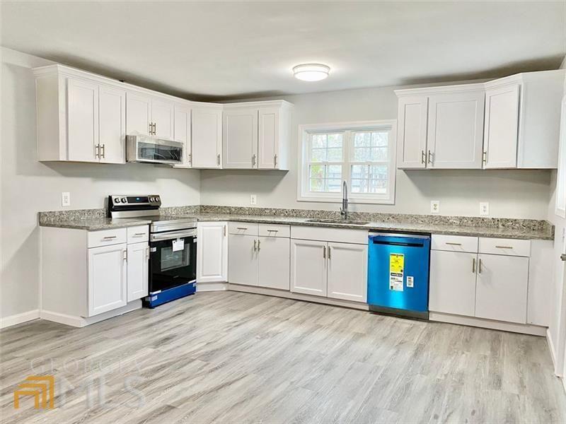 3614 Blacks Bluff Road Southwest Rome, GA 30161 - Photo 1 of 1 a kitchen with granite countertop cabinets stainless steel appliances and a wooden floor