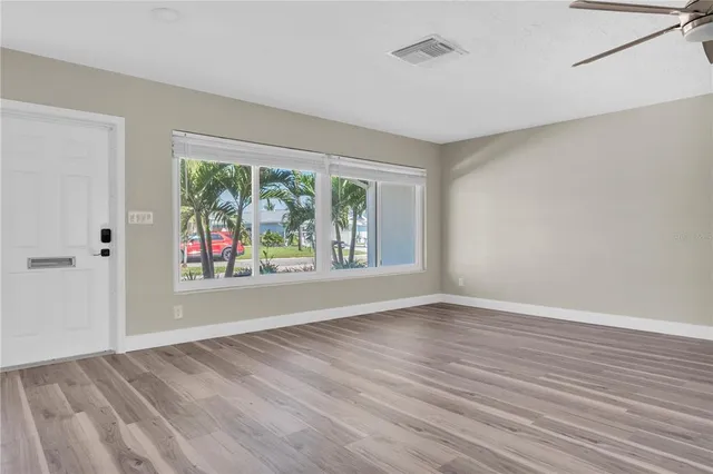 a view of an empty room with glass door and balcony