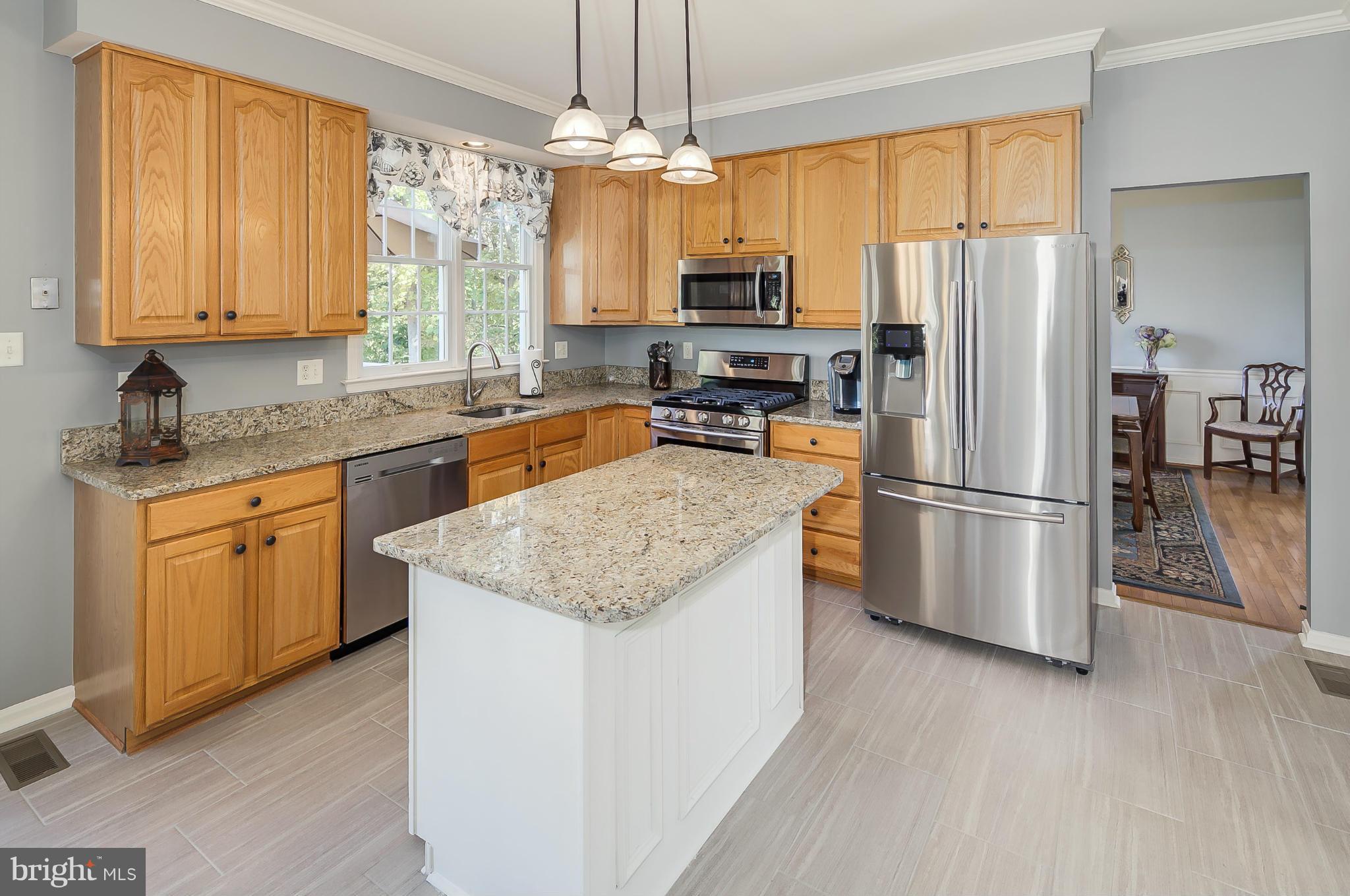 5949 Sandy Ridge Elkridge, MD 21075 - Photo 6 of 30 a kitchen with stainless steel appliances granite countertop a refrigerator a stove top oven a sink and dishwasher with wooden floor