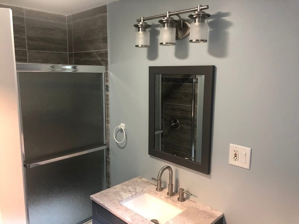 63 River Street, Unit 1 Middleton, MA 01949 - Photo 16 of 19 a bathroom with a sink and a mirror