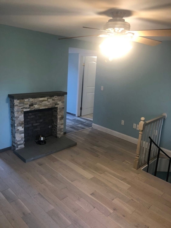 63 River Street, Unit 1 Middleton, MA 01949 - Photo 18 of 19 a view of empty room with wooden floor and fireplace