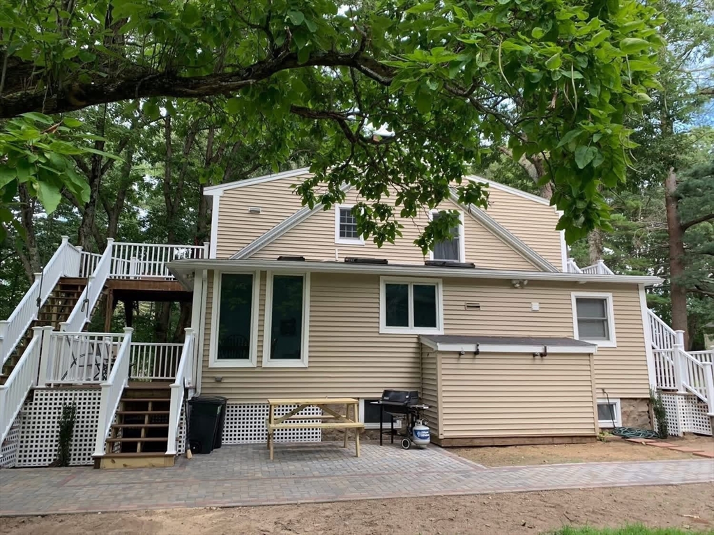 63 River Street, Unit 1 Middleton, MA 01949 - Photo 3 of 19 a view of a white house with large windows and a large tree