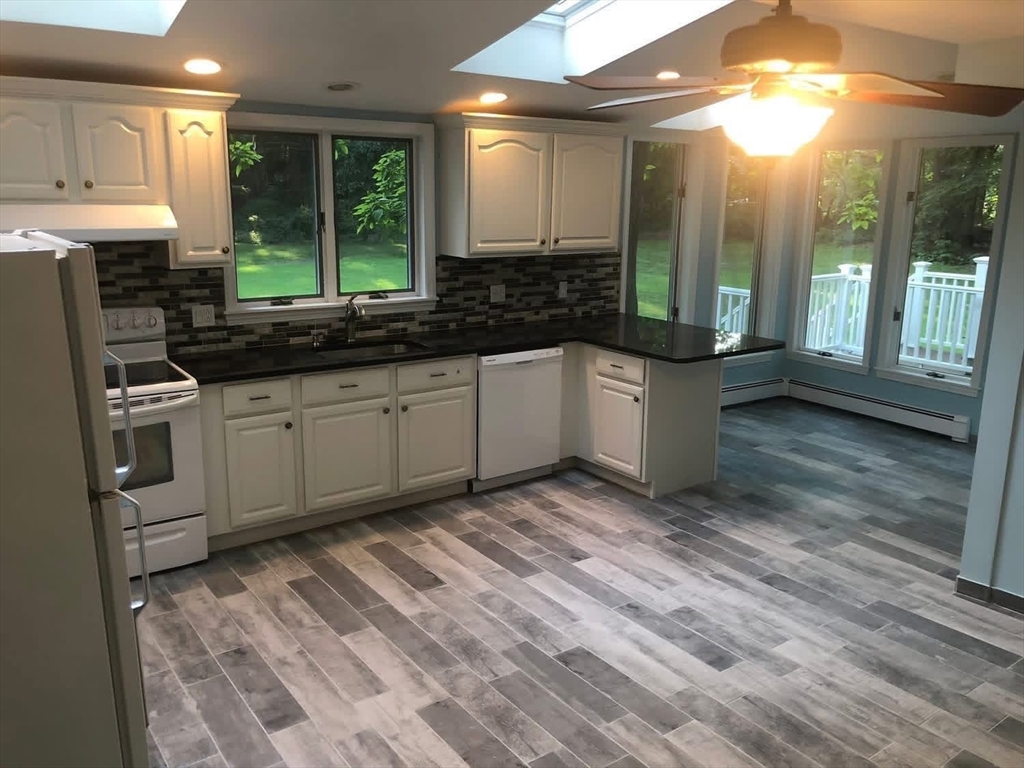 63 River Street, Unit 1 Middleton, MA 01949 - Photo 5 of 19 a kitchen with stainless steel appliances granite countertop a stove a sink and a microwave