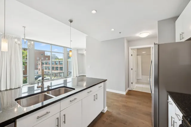 a kitchen with granite countertop a sink and a refrigerator