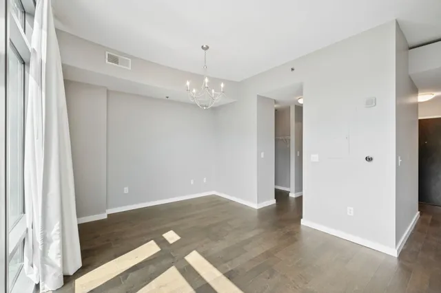 an empty room with wooden floor and entrance