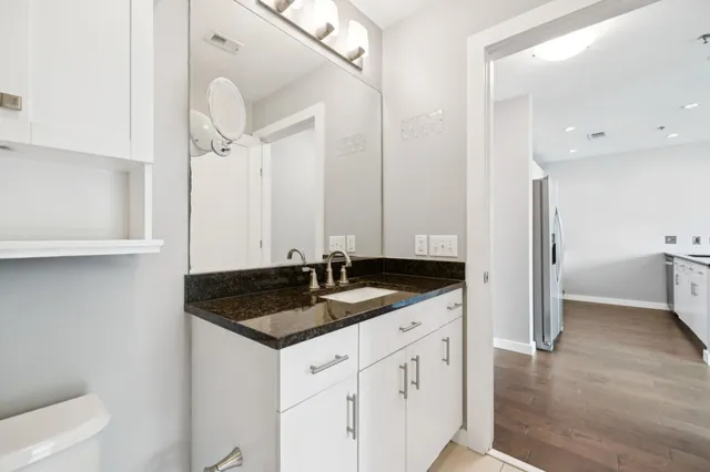 a bathroom with a granite countertop sink and a mirror