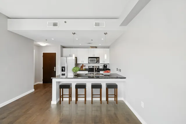 a kitchen with a table chairs refrigerator and microwave