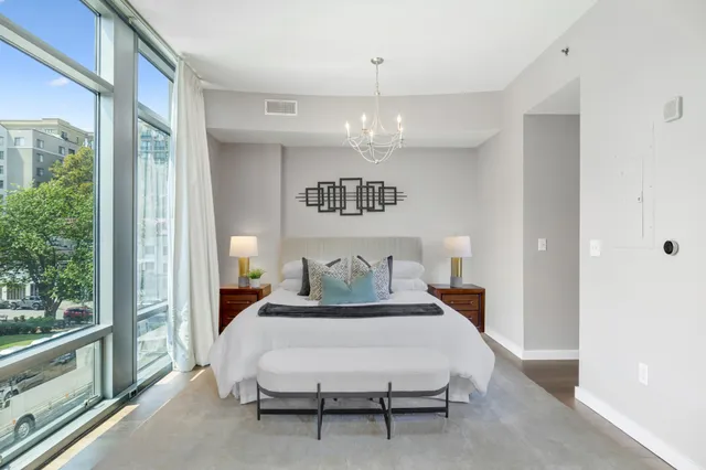 a bedroom with a large bed and a chandelier