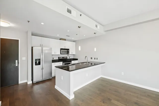 a kitchen with stainless steel appliances a sink a stove a refrigerator and cabinets