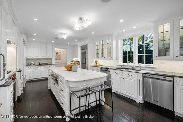 a kitchen with stainless steel appliances granite countertop a stove top oven a sink dishwasher a dining table and chairs with wooden floor