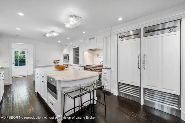 a kitchen with a table chairs refrigerator and wooden floor