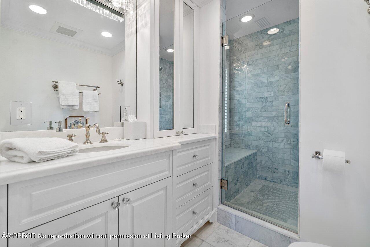 100 Regents Park Road Palm Beach, FL 33480 - Photo 22 of 42 a bathroom with a shower sink and mirror