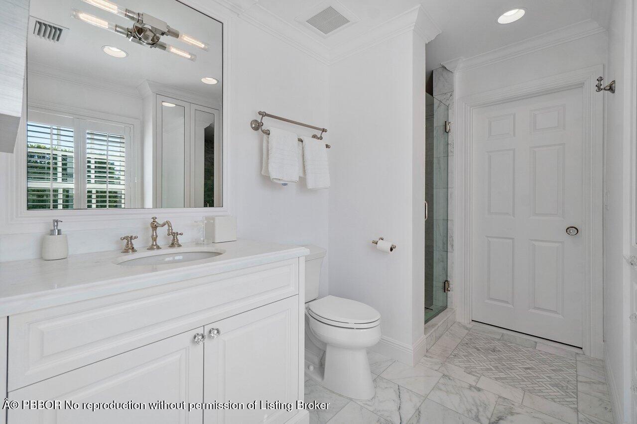 100 Regents Park Road Palm Beach, FL 33480 - Photo 24 of 42 a bathroom with a sink a toilet and a mirror