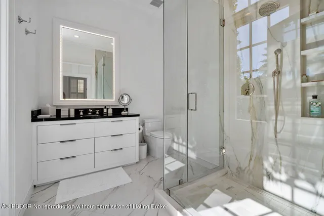 a bathroom with a double vanity sink toilet and shower