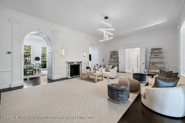 a living room with furniture a fireplace and a chandelier