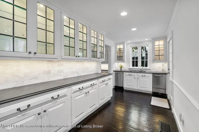 a kitchen with stainless steel appliances kitchen island granite countertop a sink and cabinets with wooden floor