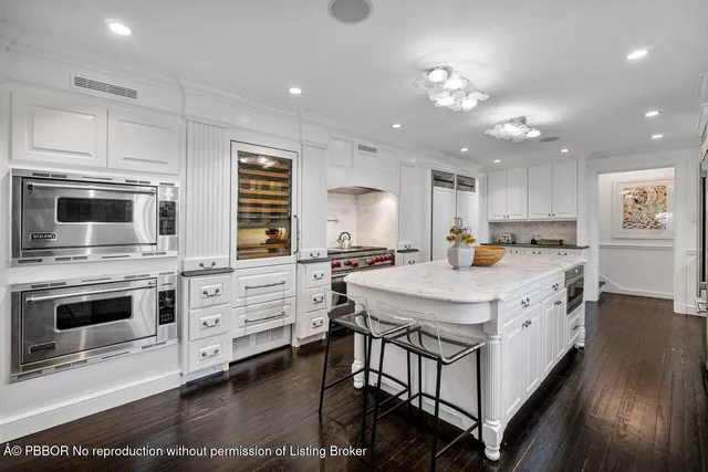 a kitchen with kitchen island granite countertop a stove cabinets and wooden floor
