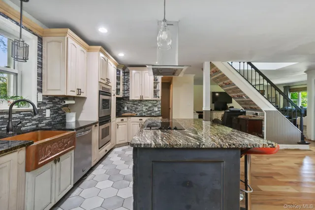 a kitchen with stainless steel appliances granite countertop a sink refrigerator and cabinets