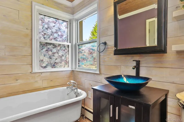 a bathroom with a bathtub sink and mirror