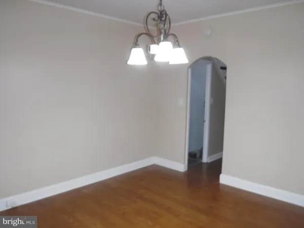 a view of empty room with wooden floor and window