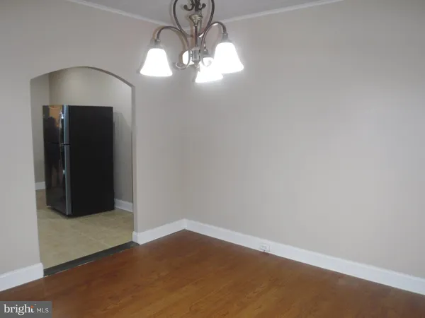 a view of wooden floor and a chandelier in a room