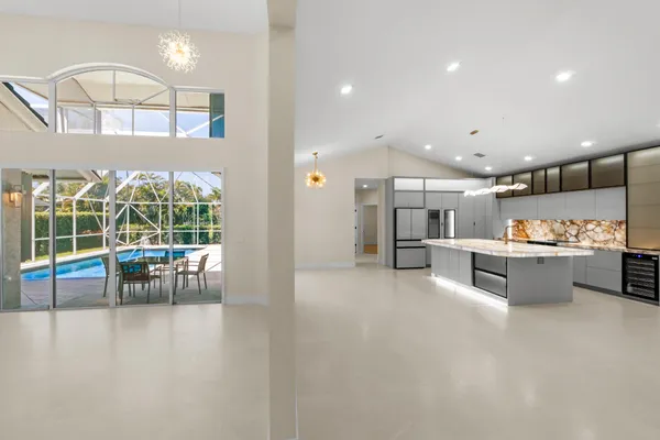 a open kitchen with white cabinets and outdoor space