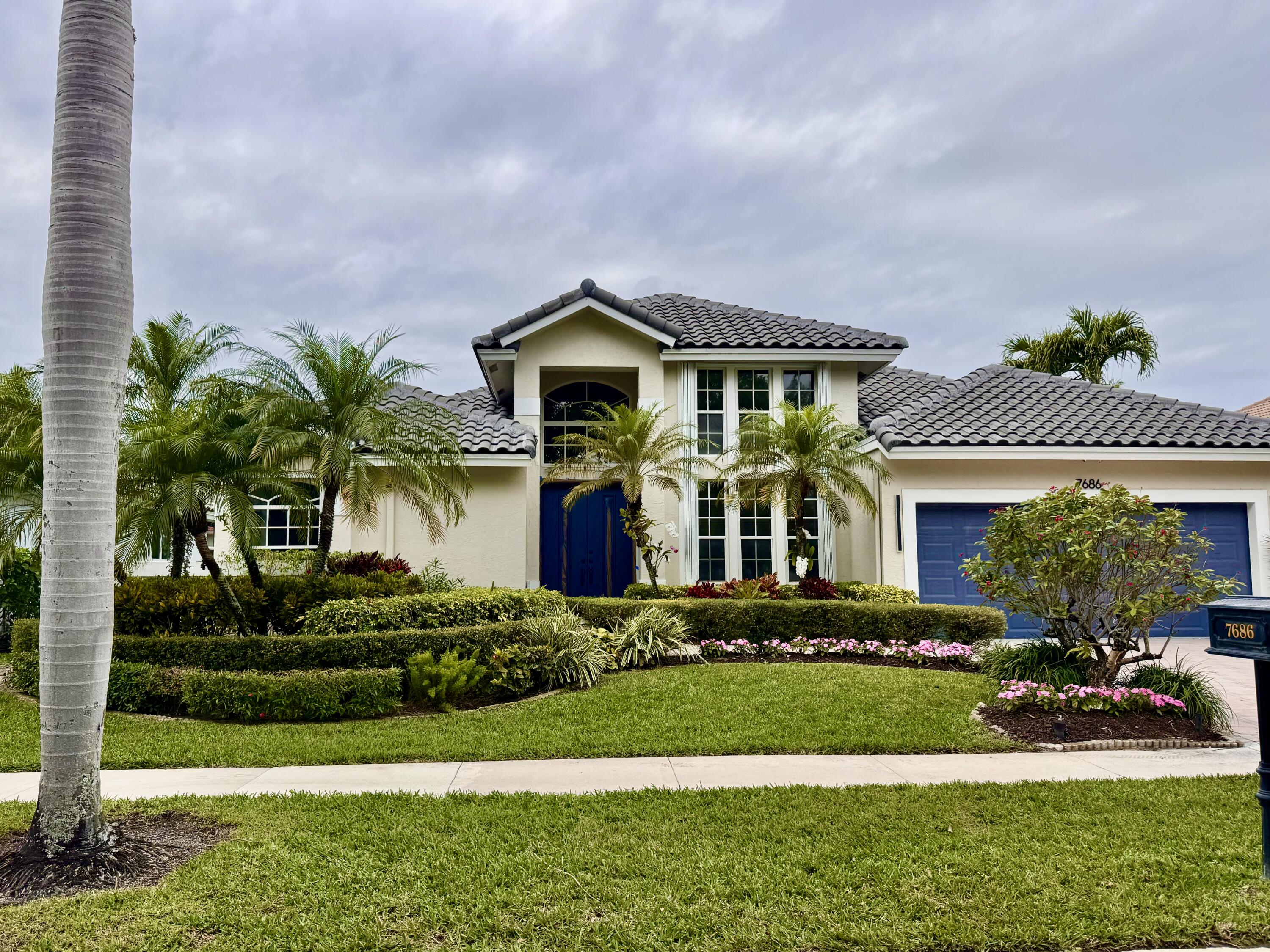7686 La Corniche Circle Boca Raton, FL 33433 - Photo 34 of 35 a front view of a house with a garden