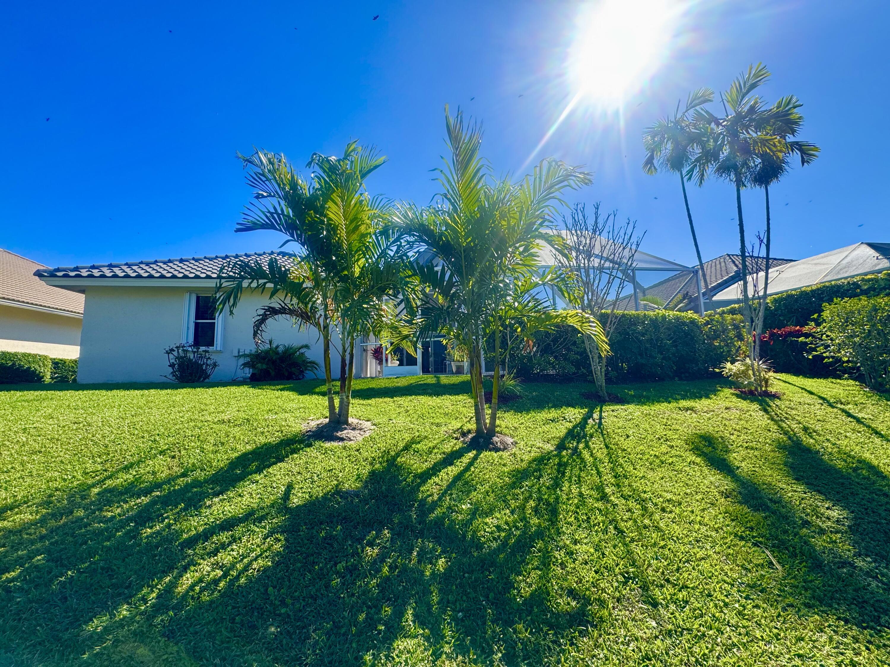 7686 La Corniche Circle Boca Raton, FL 33433 - Photo 35 of 35 a yellow house with a yard and palm trees