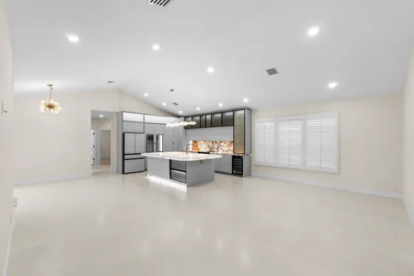 a kitchen with kitchen island granite countertop a oven and a refrigerator