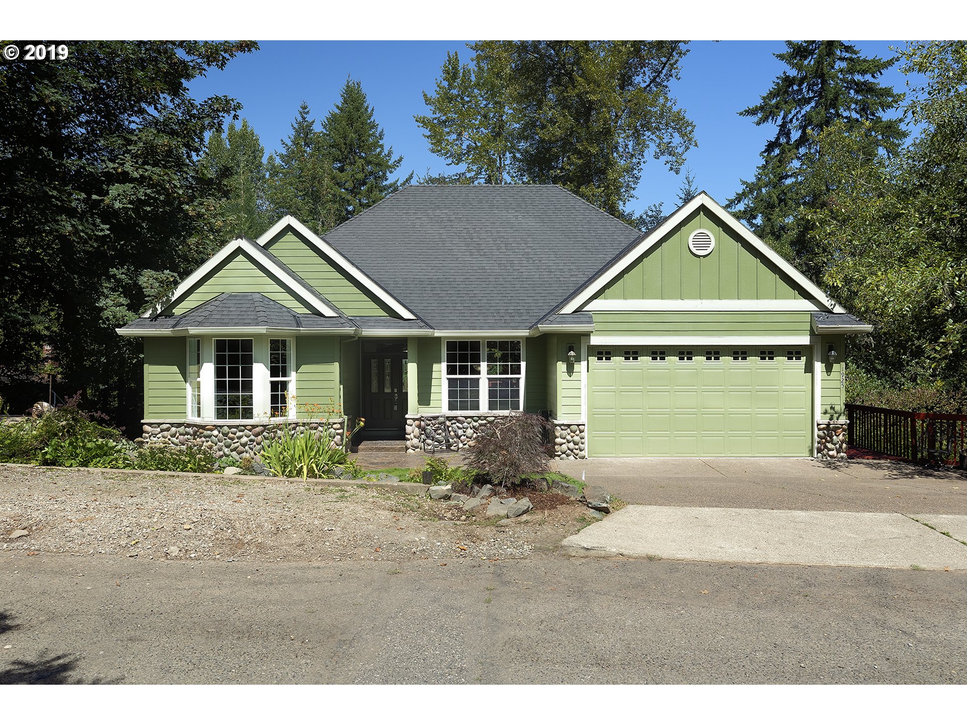 a front view of a house with a garden and yard