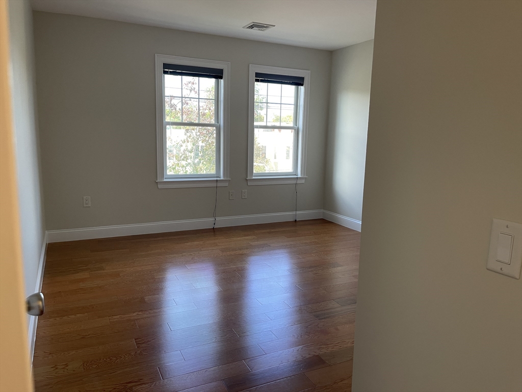 5170 Washington Street, Unit 3 Boston, MA 02132 - Photo 20 of 42 wooden floor in an empty room with a window