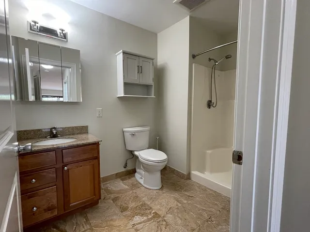 a bathroom with a toilet and a shower