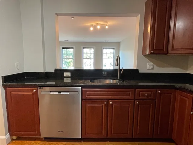 a kitchen with granite countertop wooden cabinets and a sink