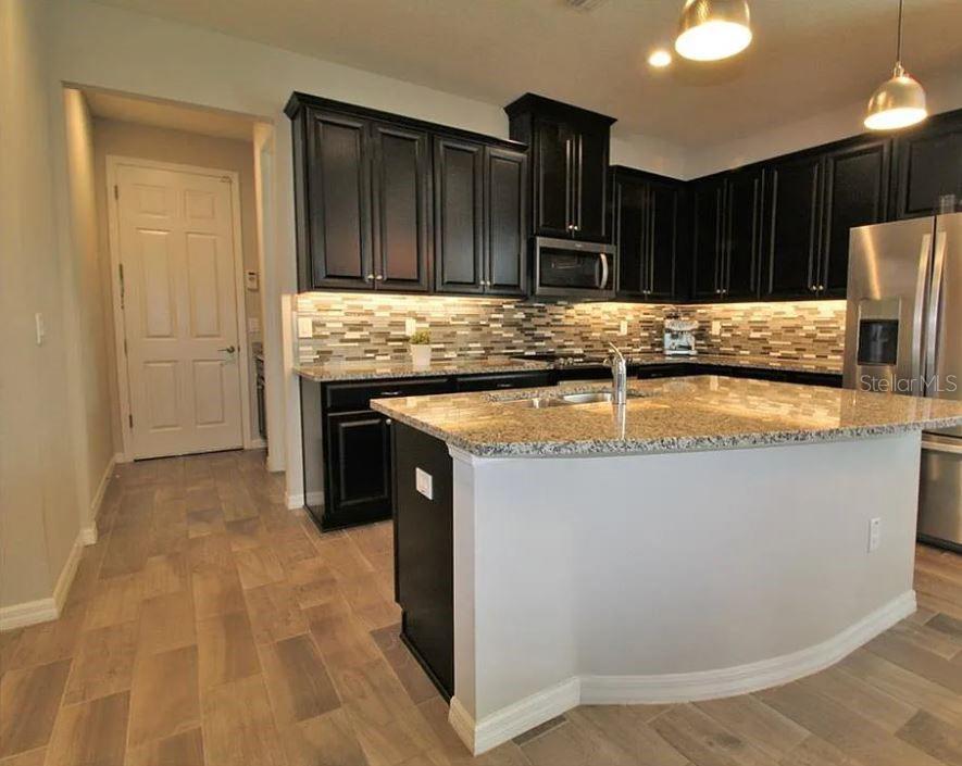 1049 Multiflora Loop Lutz, FL 33558 - Photo 15 of 49 a kitchen with kitchen island granite countertop a stove and a sink